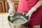 The girl mixes the ingredients for the cake by hand with a spatula, makes the cream and the filling