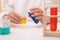 Girl mixing colorful liquids at white table indoors, closeup. Chemical experiment set for kids