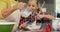 Girl mixing the flour while grandmother pouring milk into the bowl 4K 4k