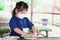 Girl mixing white clay with salt and water to create viscous consistency. Child in food preservation class. Little farmer.