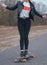 Girl model skateboarding on a rural road, modern girl in leather jacket on a skateboard