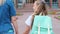 Girl and mommy walk joining hands to school on warm day