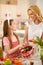 Girl with mother preparing Easter basket with eggs