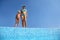 Girl with mother stand on skirting of pool