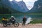 Girl motobiker in protective turtle jacket stands on the beach with tourer motorcycle. Extreme travel vacation, motorcyclist