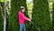 Girl mows the lawn on a sunny day with an electric lawn mower