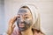 Girl with mud mask touching her face