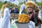 Girl in  national Bashkir attire carries a dish `CHAK-CHAK` on a tray, front view