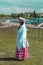 Girl in national Bashkir clothes is standing at `Sabantui` holiday, side view