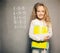 Girl near blackboard with book