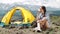 Girl near bonfire. Travel, tourism, camping - young slim sporty woman tourist brunette at the beautiful nature landscape