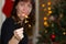 The girl near a Christmas tree with sparkler.