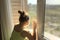 Girl near a masked window, quarantine.