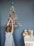 Girl near original Christmas tree made with branches, ecological toys, zero waste holidays