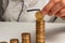 Girl neatly stacks coins in a pile while sitting at a table