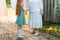 Girl next to an elderly woman. granddaughter helps her grandmother. a girl in a green dress is holding clothespins for wet clothes