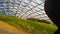 A girl with a notebook sits on the lawn under the dome