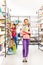 Girl with notebook stands in library near shelves