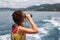 Girl observing in binocular sea coast