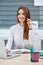 Girl office worker sitting at desk in headphones and with laptop.