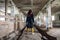 A girl in an old abandoned scary room like a barn or stable. An abandoned factory barn and stable where cows and horses lived.