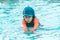Girl in orange and blue suit is swimming in a water park pool