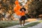 Girl with orange halloween balloons posing on the street. Halloween concept.