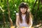 Girl and oranges. Girl playing with oranges at a table in nature. Child with oranges. Happy girl with fruits on nature.