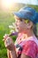 A girl in ordinary clothes sniffs a bouquet of wild flowers and closes her eyes with pleasure. Daisies, purple buds and yellow