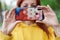 The girl is out of focus holding a mobile phone in a beautiful case with both hands