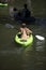 Girl with paddle riding on the lake in kayak along with other people resting