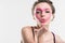 girl with painted pink heart on face sending air kiss