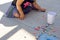 Girl painting on a pavement with many different color chalk