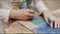 Girl paints cardboard figure with blue marker at table