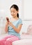 Girl in pajamas text messaging with cell phone