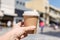 Girl with paper cup of coffee on a street. Coffee take away. Selective focus.