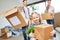 Girl and parents carry moving box