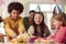 Girl With Parents And Friends At Home Celebrating Birthday Eating Snacks At Party