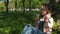 Girl in the park with coffee. A teenage girl in a jeans suit is sitting under a tree. The sad girl drinks coffee.