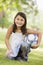 Girl in park holding football