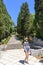 Girl on a park path amid high cypress trees