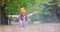 Girl in a park playing with fallen autumn leaves