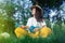 Girl in the park sitting on the grass plays the ukulele. Learning to play a four-string instrument. Relaxation in a public park.