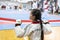 a girl participates in Taekwondo competitions in a sports kimono on the background of Taekwondo competitions close up