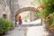 Girl passing by an arch made of stone in Peratallada