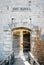 Girl peeks out from behind the ajar wooden door of Mamula Fort