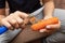 Girl peeling boiled carrots with a knife