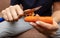 Girl peeling boiled carrots with a knife