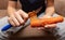 Girl peeling boiled carrots with a knife