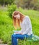 girl with pen writing on notebook on grass outside